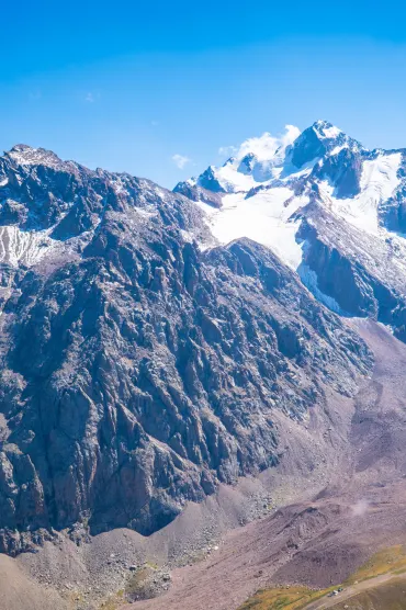 A breathtaking view of the Tian Shan mountains in Almaty, showcasing rugged peaks and snow-capped summits.